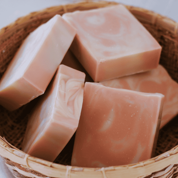 a basket of pink and white peppermint cedarwood tallow soaps