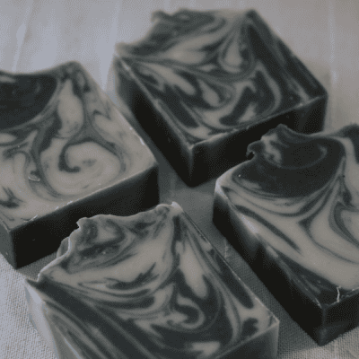 4 bars of Superior Stone Charcoal Bar laying on side to show the patterns in the soap.