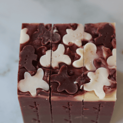 gingerbread soap tops of gingerbread mand tallow soap bars - embeds of gingerbread men in white and dark red