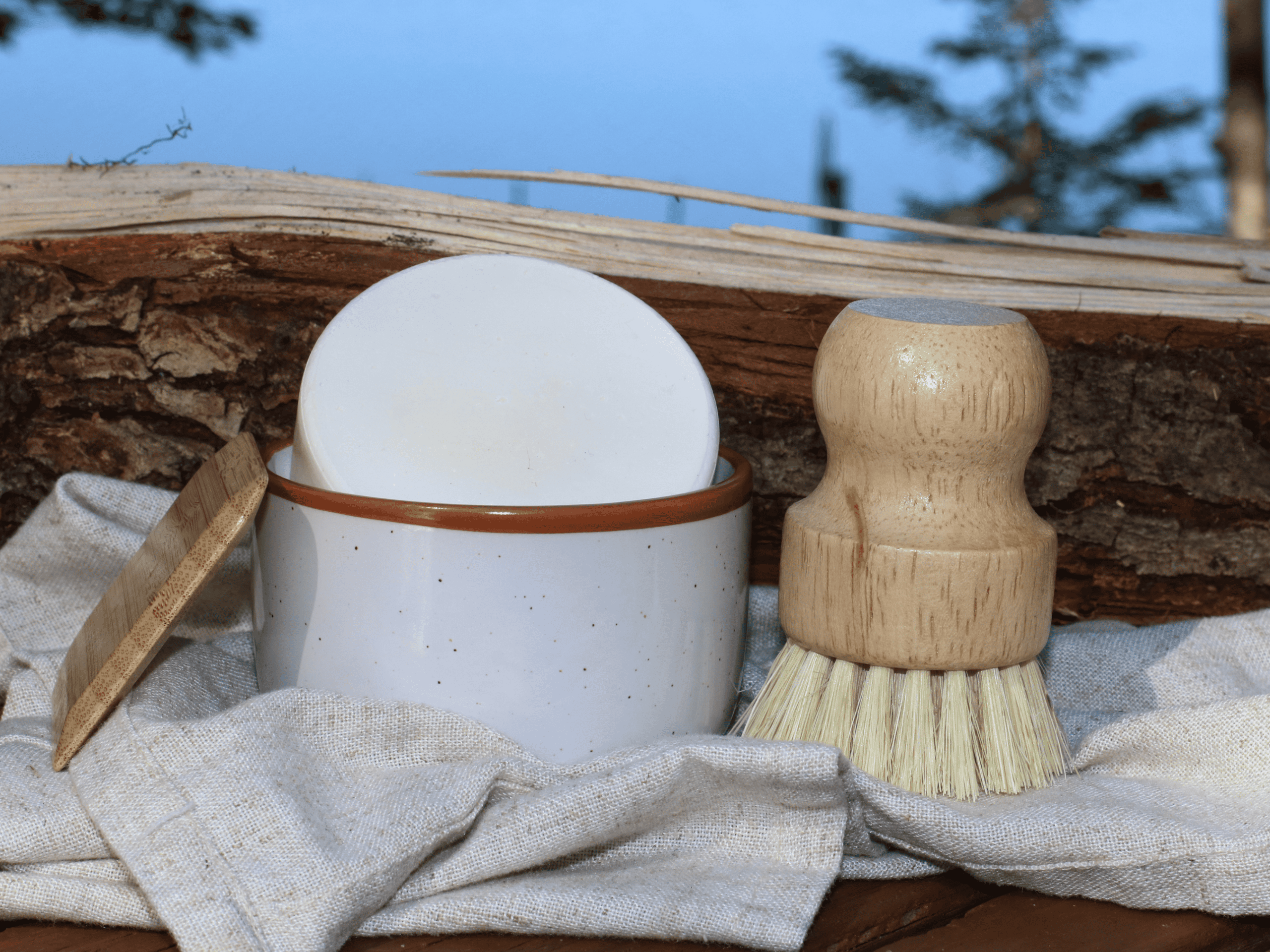 White ramekin for dish soap bar. with dish brush and bamboo scraper.